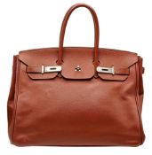 An Hermès Brick Red Courchevel Birkin 35 Handbag. Brick red Courchevel leather exterior with