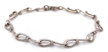 AN 18K WHITE GOLD INFINITY LINK BRACELET WITH SMALL DIAMOND DECORATION. 8.4g. 18cm.