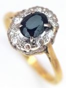 An 18K Yellow Gold, Sapphire and Diamond Ring. Oval cut sapphire with a diamond surround. Size P.