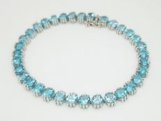 A Gorgeous 14K White Gold and Blue Topaz Bracelet. 34 round cut Topaz in claw settings. c.10ctw.