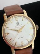 Gentleman’s vintage 14 CARAT GOLD ‘HUGUENIN’ AUTOMATIC WRISTWATCH. Brown leather strap. Full working