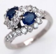 AN 18K WHITE GOLD, DIAMOND AND SAPPHIRE SET, TWIST DESIGN RING. 0.50CTW DIAMONDS AND 0.50CTW