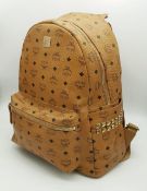 An MCM Visetos Large Stark Backpack. Cognac MCM monogram coated canvas exterior with gold-toned