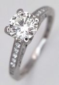 An Elegant 18K White Gold and Diamond Ring. A circa 0.70ct round brilliant cut diamond centre