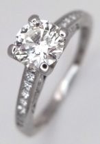 An Elegant 18K White Gold and Diamond Ring. A circa 0.70ct round brilliant cut diamond centre