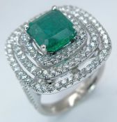 A Stunning 18K White Gold, Zambian Emerald and Diamond Cocktail Ring. A 3.28ct emerald has three
