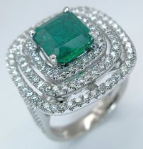 A Stunning 18K White Gold, Zambian Emerald and Diamond Cocktail Ring. A 3.28ct emerald has three