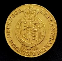An 1802 George III Half Guinea Coin. Obverse - Sixth laureate head. Reverse - Shield in garter. Date
