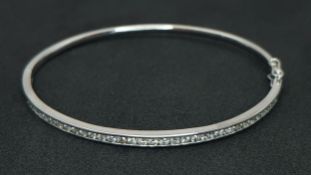 AN 18K WHITE GOLD, DIAMOND SET BANGLE. 1.00CTW DIAMONDS. 6CM INNER DIAMETER. 11.2G. SC 7087