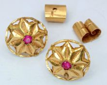 A Pair of 18K Yellow Gold (tests as) and Ruby Floral Form Stud Earrings. 1.6g total weight.