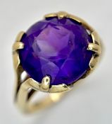 A 9K Yellow Gold and Amethyst Cocktail Ring. A 6ct round cut amethyst in a claw setting. Size N 1/2.