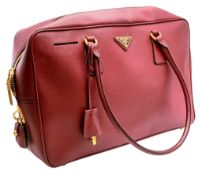 A Prada Two Way Saffiano Leather Handbag. Burgundy Saffiano leather exterior with gold-tone