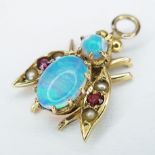 An 18K Gold, Opal and Ruby Pendant in Bee Form. 2cm. 1.25g total weight.