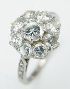 A Gorgeous Platinum Diamond Ring in Floral Form. A 0.40ct round brilliant cut centre diamond with