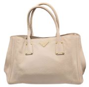 A Prada Vitello Daino Leather Tote Bag. Beige pebbled leather exterior with gold-tone hardware,