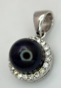 A 14K White Gold Pendant with Black Pearl and Diamond Surround. c. 0.20ctw diamonds. 2cm. 2.95g