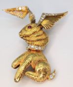 An 18K Yellow Gold (tests as) and Diamond Winged Rabbit with Ruby Eye Brooch. 5cm x 4cm ear-span!