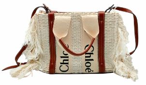 A Chloé Woody Fringed Tote Bag. Cream woven textile exterior with long fringed sides, tan leather