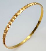 A 22K Yellow Gold Decorative Engraved Bangle. 4mm width. 60mm inner diameter. 11.7g