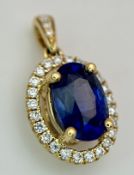 An 18K Gold Sapphire and Diamond Pendant. A 1ct oval cut deep blue Madagascan sapphire with a