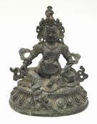An antique Tibetan Bronze Guardian Deity Figure. Depicted wearing armor and a jeweled crown, exuding