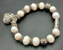 A Pretty Freshwater Pearl and Silver-Tone Heart Charm Bracelet. Set with irregular shaped freshwater