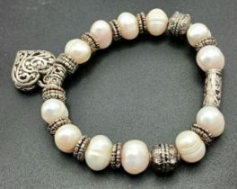 A Pretty Freshwater Pearl and Silver-Tone Heart Charm Bracelet. Set with irregular shaped freshwater
