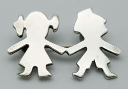A Vintage Sterling Silver Brooch. Formed as a stylised boy and girl holding hands. Measures 4.4cm