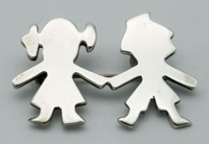 A Vintage Sterling Silver Brooch. Formed as a stylised boy and girl holding hands. Measures 4.4cm