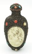 A Chinese White Metal Mounted Snuff Bottle. Decorated with intricate scrollwork and set with multi-