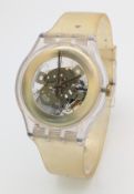 A SWATCH, GILT GHOST, RUBBER STRAP WATCH. MODEL SUOK106. IN WORKING ORDER. NEW BATTERY FITTED