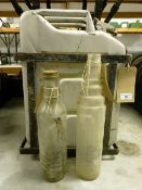 Two glass oil bottles, and a jerry can, in an iron frame (3) Collection from DT2 0PR will be on