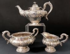 A Victorian Irish silver three piece tea service, with embossed decoration, comprising a teapot,