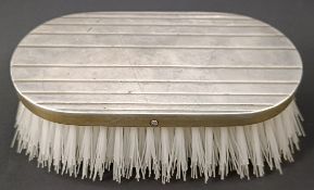 A silver backed brush, to a Cartier design, 14 cm wide