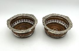 A pair of large silver plated wine coasters,