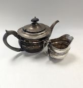 An Edwardian silver teapot and cream jug,