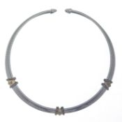 A torque style necklace, inside diameter 10.6cm, width from 9.1 to 13mm, stamped '925' and '750',