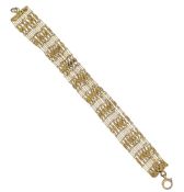 A seven row fancy rope style bracelet, length 17cm, width 1.6cm, unmarked, tested as 9ct gold,