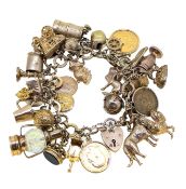 A late 20th century 9ct gold charm bracelet, rope style links, suspending thirty two charms,