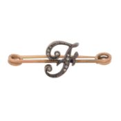 A diamond letter F brooch Yellow and white metal