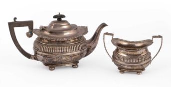 A silver teapot and sugar basin