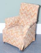 An antique high back armchair with later colourful upholstery, square wooden legs with brass