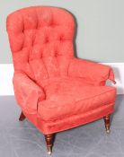 An antique button back armchair or nursing chair with red damask upholstery and wooden legs with