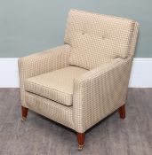 A traditional upholstered armchair, finished in a neutral cream, beige and brown small-check fabric,