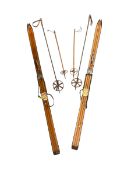 Two pairs of vintage wood skis with poles.