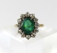 An emerald and diamond cluster ring, the oval face