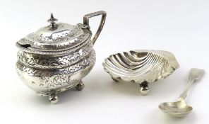 A silver dish in the shape of a shell, with three