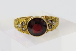 An early 20th century garnet and split pearl ring,