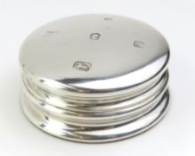 A round silver paper weight with green felt base;