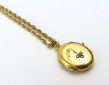 An unmarked oval shaped hinged locket, set with th